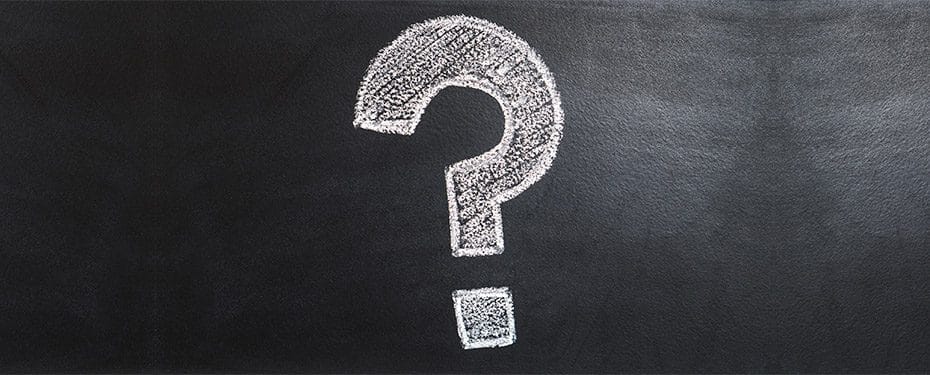 Chalk drawing of a large question mark on a blackboard background, symbolizing inquiry and curiosity.