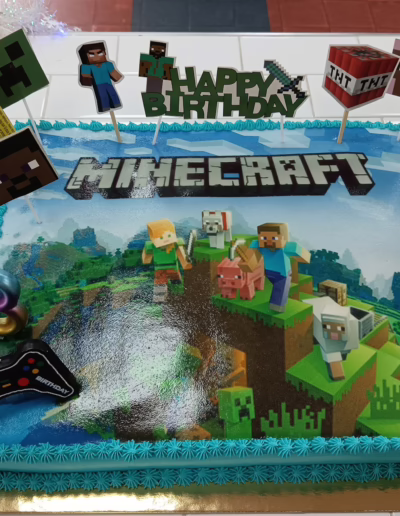 Minecraft-themed birthday cake featuring colorful edible images of characters, game elements, and festive decorations, perfect for a gaming celebration.